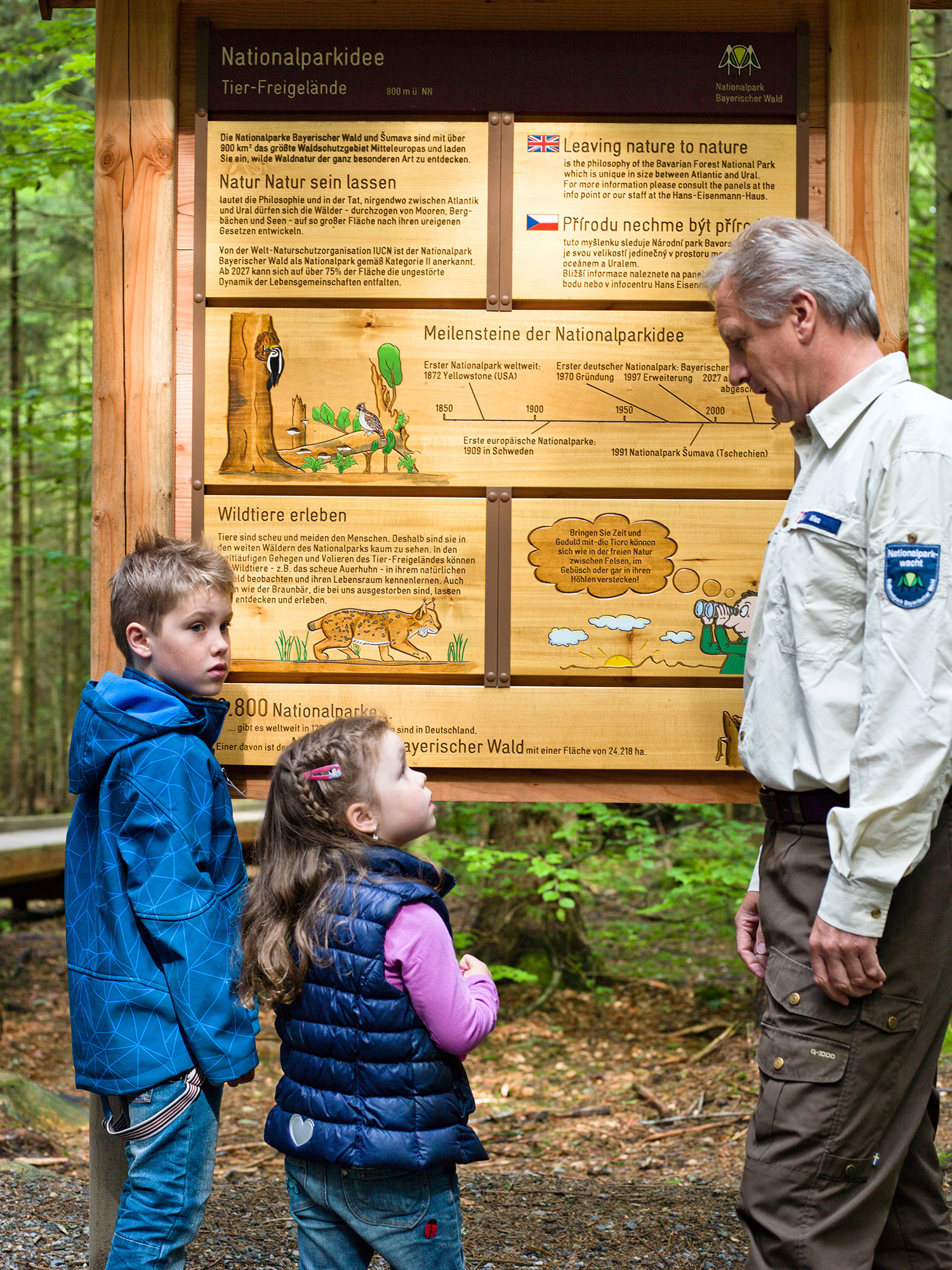 Ranger erklärt zwei Kindern Wissenswertes über den Wald